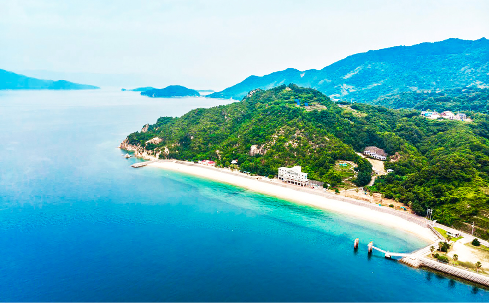 写真：江田島の青い海と白い砂浜、自然豊かな緑の山々