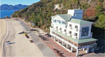 写真：目の前に澄み切った青い海と白い砂浜が広がるUminos Spa & Resortの外観