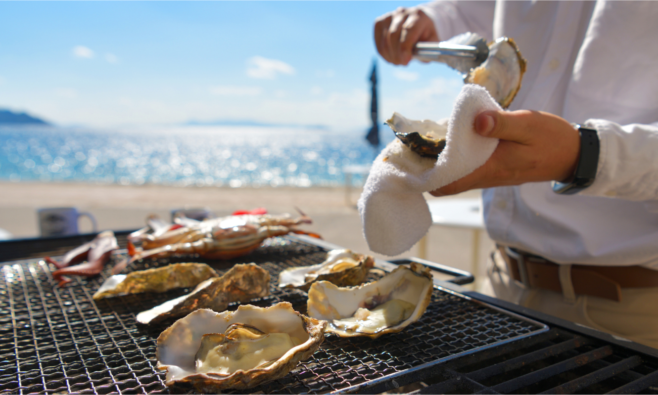 写真：牡蠣を焼いてお召し上がりいただける海辺での海鮮BBQ