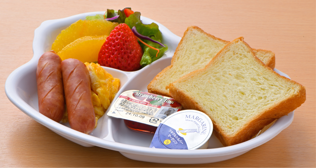 写真：パンとジャム・マーガリン、ソーセージとスクランブルエッグ、サラダ、いちごなどのフルーツなどが入ったお子様用洋食プレート
