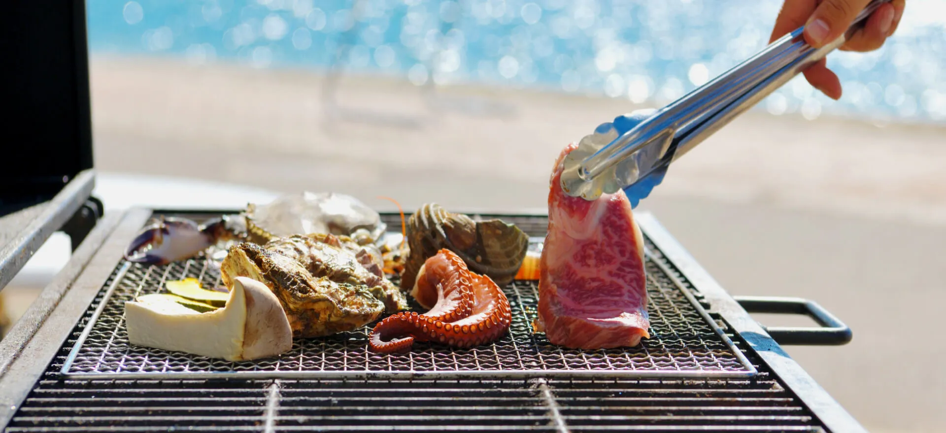 写真：きのこやお肉、タコや牡蠣など海鮮を焼いてお召し上がりいただける海辺でのバーベキュー