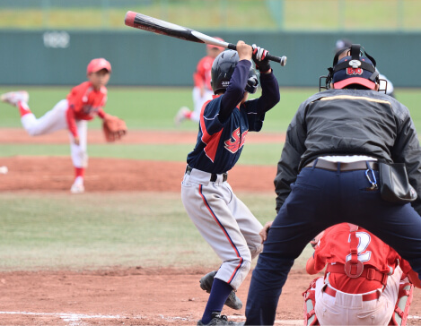 写真：少年野球の試合でボールを投げている投手とバットを構える打者