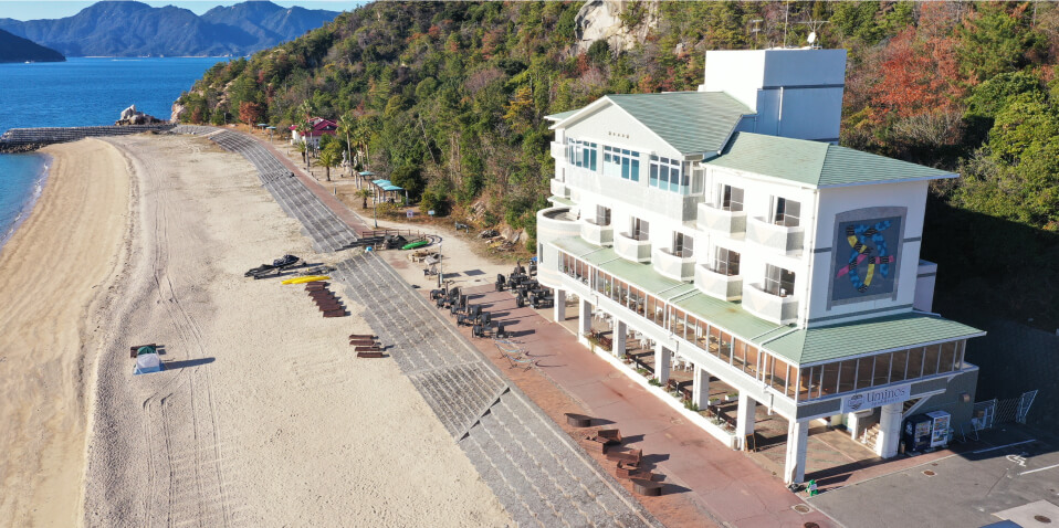 写真：海辺の砂浜とすぐ近くに建つUminos