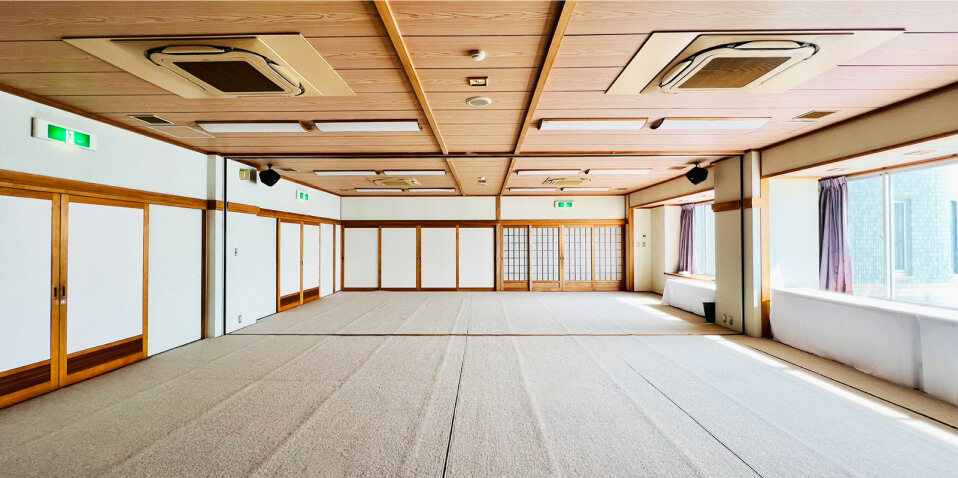 写真：広々とした和風の大広間。大きな窓があり、明るい自然光が差し込みます